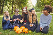 © Seventyfour - Full length portrait of multi-ethnic group of children eating candy on Halloween outdoors while wearing costumes