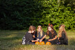 © Seventyfour - Wide angle portrait of multi-ethnic group of children eating candy on Halloween outdoors while wearing costumes, copy space