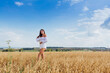 © Smile - Young beautiful woman relaxing at golden oat field.