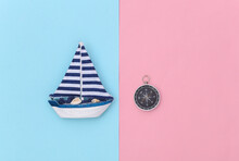 Sailboat And Compass On A Blue Pink Background. Travel, Minimalism Concept. Top View. Flat Lay