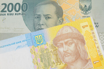 A macro image of a grey two thousand Indonesian rupiah bank note paired up with a blue, white and yellow one hyrvnia bank note from Ukraine.  Shot close up in macro.