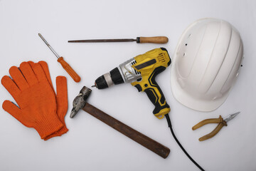 Wall Mural - Old drill screwdriver and protective helmet, gloves and work tool on white background. Top view