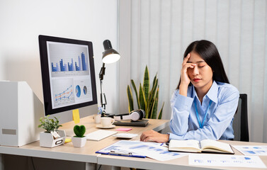 Working Asian women feel stressed, tired from work, migraine headaches from hard work while working at the office