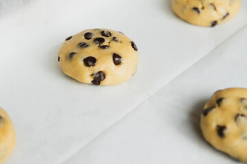 Raw chocolate chip cookie in the middle of the tray ready to bake - traditional American dessert