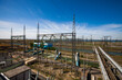 © Alexey Rezvykh - Electric power plant. Transformer station (electrical substation). High-voltage equipment. Blue sky.