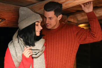 Wall Mural - Lovely couple wearing warm sweaters indoors. Winter season