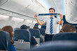 © Svitlana - Handsome steward training safety prior procedures to flight take off