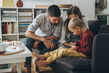 Wall Mural - cute young family using tablet together at home