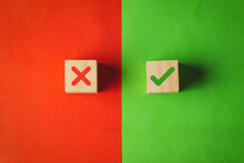 True And False Symbols, Yes Or No On Wood Cubes On Red And Green Background.