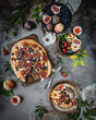 © Марина Кузнецова - fig and grape pie on wooden board with one slice cut with fresh seasonal fruits and leaves, top view, seasonal dessert