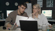 © stockbusters - Business couple working together with document data front laptop in night office