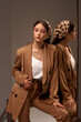 © Dmitry Tsvetkov - Tall slim elegant fashion teenager model wearing brown male style over size suit and polka dot kerchirfwith trendy makeup and brunette hair in tail. Fashionable portrait with mirrors and reflections
