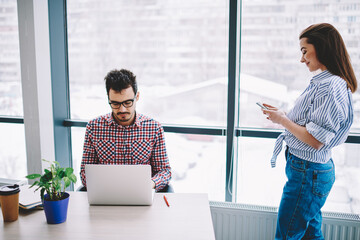 Wall Mural - smart casual man and woman using cellphone and laptop technology for sharing files connected to blue