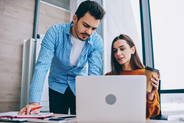Wall Mural - young male and female employees in smart casual wear discussing web projecting during distance coope
