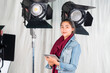© shine - Young asian woman student using a digital tablet while standing in studio with professional equipment.