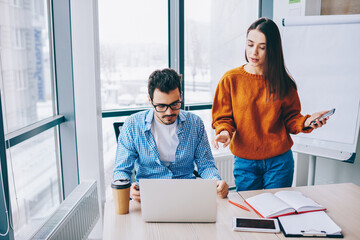 Wall Mural - young male and female employees in smart casual wear discussing web projecting during distance coope
