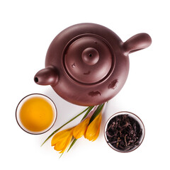 Wall Mural - Chinese tea in a cup, clay teapot with crocus flowers isolated on a white background. Top view.