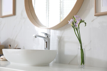 Canvas Print - Beautiful violet freesia flowers on countertop in bathroom