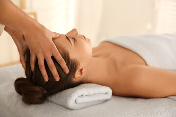 Young woman receiving head massage in spa salon