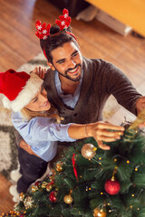 Wall Mural - Couple decorating Christmas tree