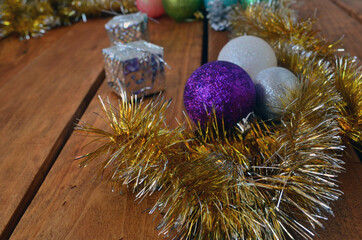 New Year's layout on a wooden background. Christmas decorations for the tree, balls, gifts.