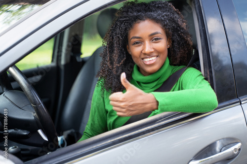 Portrait of confident black woman driving her new car