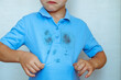 © HalynaRom - upset boy showing a stain on his clothes The concept of cleaning stains on clothes. Isolated on a white background