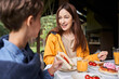 © Yakobchuk Olena - Charming young woman having breakfast with son outdoors