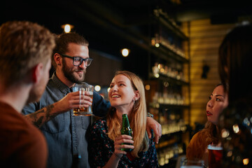 Wall Mural - Group of best friends hanging on in a pub, chatting, laughing and drinking beer.