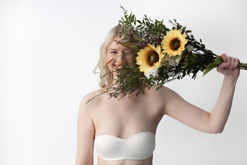 Wall Mural - Joyful young woman holding bouquet with sunflowers