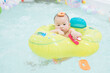 © Miss Rein/Stocksy - Baby wearing swimming ring
