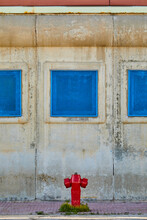 Red Fire Hydrant At Old Wall With Blue Window