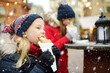 © MNStudio - Cute young girls eating crepe pancake on traditional Christmas fair in Vilnius, Lithuania. Children enjoying sweets, candies and gingerbread on Xmas market.