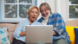 © TommyStockProject - Excited senior couple read good news on laptop sitting on couch at home