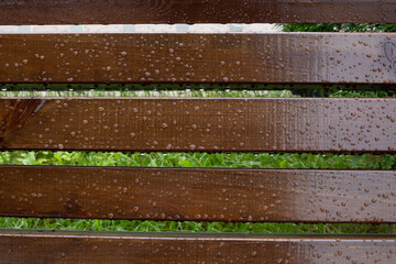 Drops of water on wooden bench after the rain, natural weather background