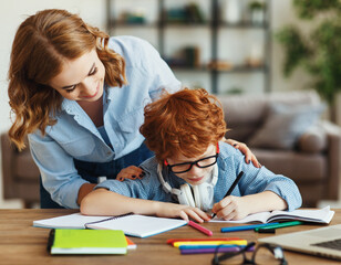 Wall Mural - Mother helping child with homework, looks at her son's notebook at home.