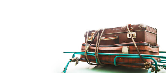 Old vintage suitcases tied with rope on roof of green car, isolated on white background for lettering. Concept of trip or travel to country for picnic for family holiday. Copyright space for banner