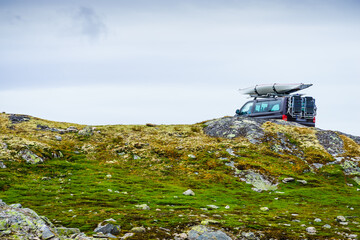 Wall Mural - Car with canoe on top roof in mountains