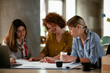 © JustLife - Businesswomen working on a new project. Colleagues discussing about problem they have to solved.