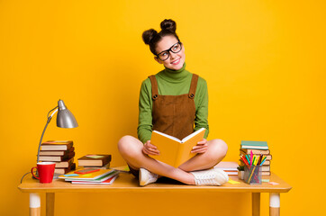 Poster - Full size photo of minded curious girl sit table legs crossed read book look copyspace think thoughts wear green jumper dress skirt overall isolated bright shine color background