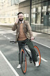© AnnaStills - Successful businessman talking on mobile phone during his ride on a bike in the city