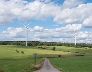 Wall Mural - countryside of german eifel with road and wind turbines