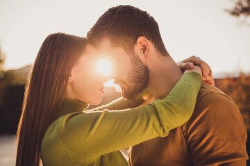 Sticker - Photo of affectionate bonding couple hug cuddle under autumn sun shine sky in fall october park wear turtleneck jumper