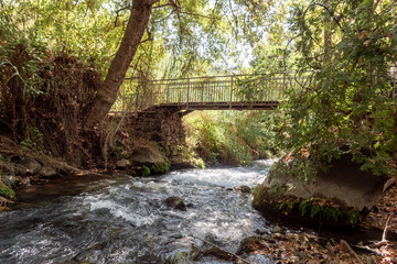 the bridge over the swift mountainous hermon river with crystal clear waters in the golan heights in