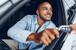 © fotofabrika - Portrait of a handsome happy African American man sitting in his newly bought car