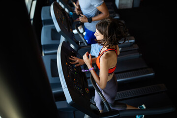 Group of young people running on treadmills in modern sport gym