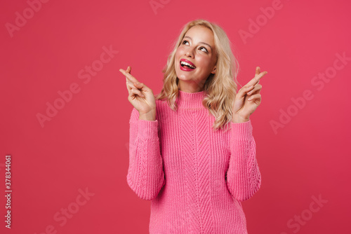 Fotomural Image of happy blonde woman holding fingers crossed for good luck