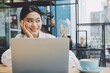 © Mallika - Asian woman using laptop in coffee shop