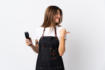 Young hairdresser slovak  woman isolated on white background pointing to the side to present a product