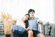 © Kris Tan - Happy young couple sitting on cough and watching TV at home.